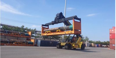 A large piece of industrial machinery being loaded onto a specialized transport vessel for Project and Oversized Cargo.